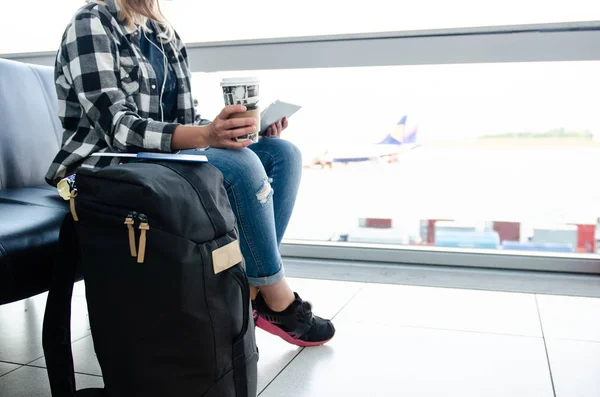 Mujer sosteniendo en la mano tableta y café y esperando el vuelo w —  Fotos de Stock