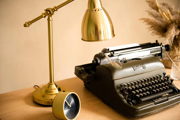 Retro skrivmaskin med guld lampa på bordet — Stockfoto
