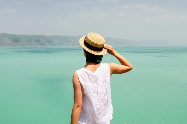 Jonge vrouw toerist op zoek naar voren in de buurt van Sevan Lake, back View — Stockfoto