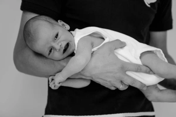 Эмоциональный новорожденный ребенок в родительских руках — стоковое фото