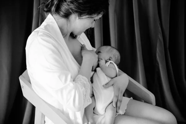 Jovem mulher amamentando seu filho infantil — Fotografia de Stock