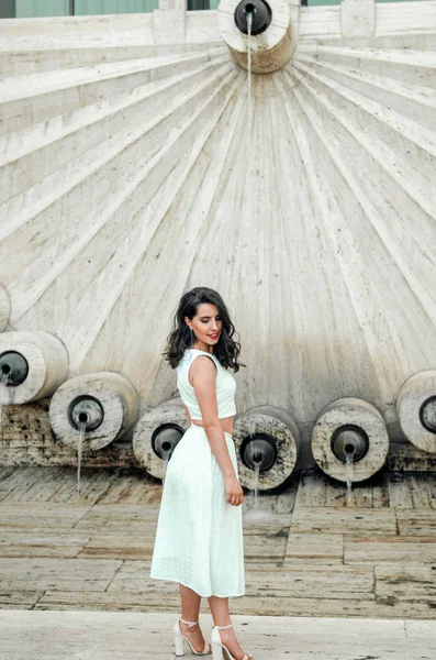 Joven mujer en vestido blanco fuera posando y sonriendo — Foto de Stock