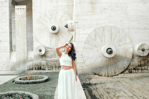 Jovem mulher de vestido branco fora posando e sorrindo — Fotografia de Stock