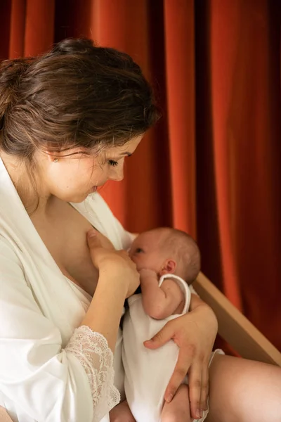 年轻妇女母乳喂养她的婴儿与谷物效果 — 图库照片