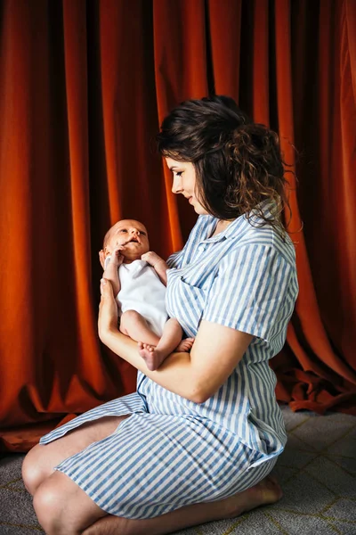 Ung kvinna som håller sitt spädbarn barn — Stockfoto