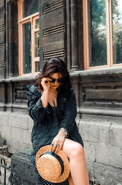 Schöne Frau in gepunktetem Kleid und schwarzer Jeans posiert in einem Zitat — Stockfoto