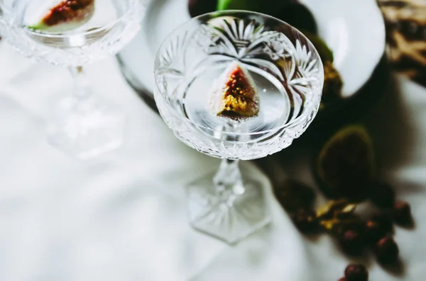 Hermosas copas de champán de cristal con higos y nueces en la mesa — Foto de Stock