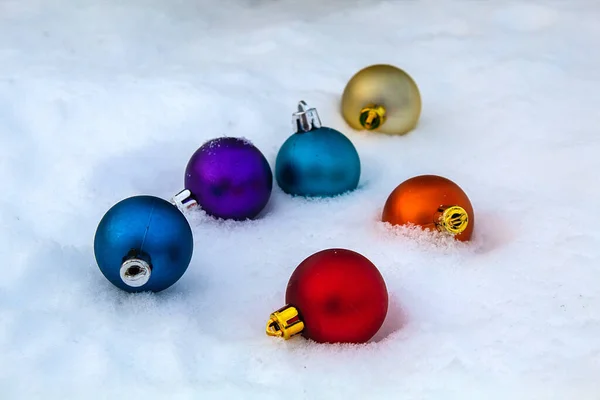 Beyaz, soğuk kar üzerinde renkli boncuklar. Temiz havada Noel.