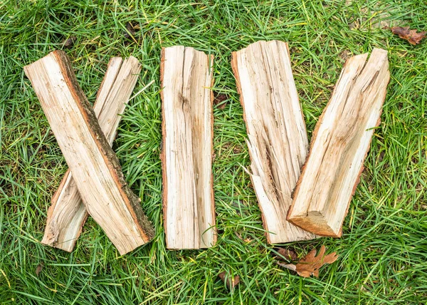 Roman numeral. Roman numerals made from oak. Old wood numbers. Old roman antique alphabet number on green grass background. Number fourteen.