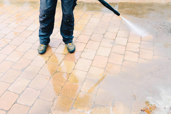 Outdoor floor cleaning with high pressure water jet - cleaning concrete block floor on terrace