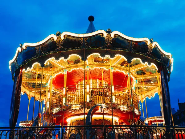 Carousel at an amusement park in the evening and night illumination - a swinging carousel fair ride in amusement park at dusk