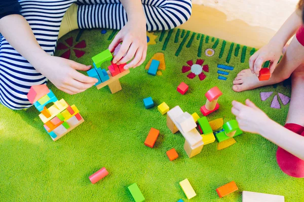 Små Barn Leker Med Träklossar Gröna Mattan Kort Skärpedjup — Stockfoto