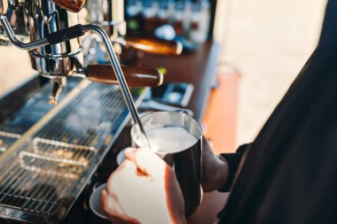 Barista kahve dükkanında makine ile süt sıcak cappuccino için Buhar