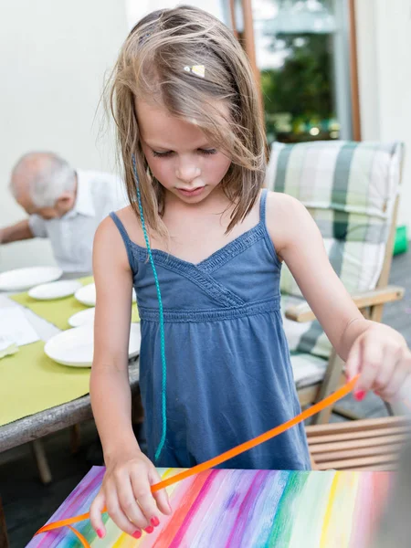 小さな女の子は、庭のパーティー中に誕生日プレゼントを開きます — ストック写真