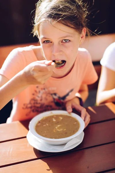 Pembe t-shirt sıcak bir çorba yeme küçük kız — Stok fotoğraf