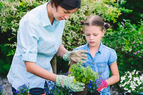 Madre e figlia piantare fiori in vaso in giardino — Foto Stock