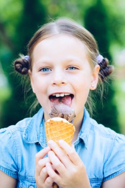 dondurma yiyen küçük kız gülümseyerek