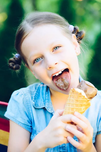 Улыбающаяся маленькая девочка ест мороженое — стоковое фото