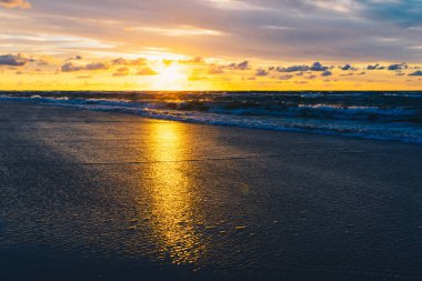 Deniz kumlu plaj üzerinde gün batımı