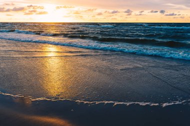 Deniz kumlu plaj üzerinde gün batımı