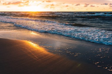 Deniz kumlu plaj üzerinde gün batımı