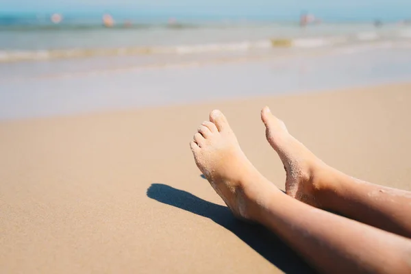 Nahaufnahme der Füße eines Kindes, das am Strand liegt, Fokus auf die Fußspitze — Stockfoto