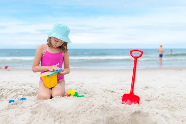 Ευτυχισμένο παιδί που παίζει με άμμο στην παραλία το καλοκαίρι — Φωτογραφία Αρχείου