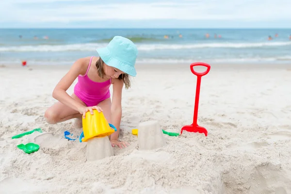 Mutlu çocuk kız yaz aylarında plajda kum ile oynarken — Stok fotoğraf