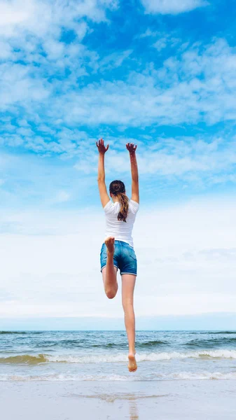 Happy girl jumping on the beach — Stock Photo, Image