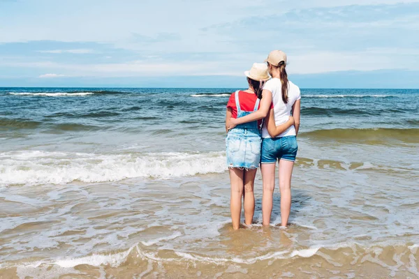 Duas amigas na costa do mar abraçando umas às outras — Fotografia de Stock