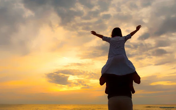 Silhouette of little girl on dad's shoulders — Stock Photo, Image