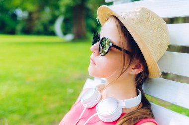 bahçede asılı ahşap sandalyede dinlenmiş kız