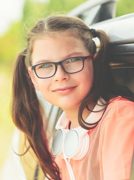 Etrafında kulaklık ile gözlük sevimli bir genç kız Portresi — Stok fotoğraf