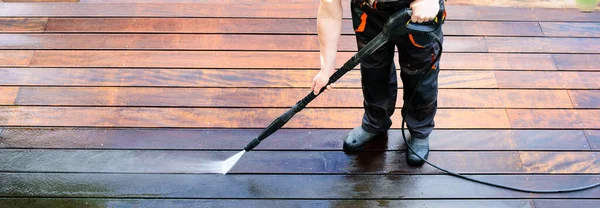 Elektrik yıkama - teras temizleyicisi ile adam temizleme - ahşap teras yüzeyinde yüksek su basıncı temizleyici