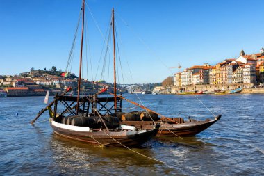 Douro Nehri ve Porto şehri manzarası, şarap fıçılarıyla dolu büyük tekneler, şarap taşımak için en ünlü köprü ve tekneler.