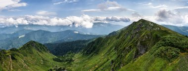 Ukrayna Karpatları 'nın yaz panoraması, üst Marmaros sırtının yeşil yamaçları. Sırt çantalı bir grup turist tepe boyunca ilerliyor..