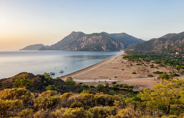 Morgen am Strand im Dorf Cirali. Boote und Schiffe in der Ferne des Taurusgebirges liegen in Ufernähe. Landschaften des Lykischen Weges. — Stockfoto