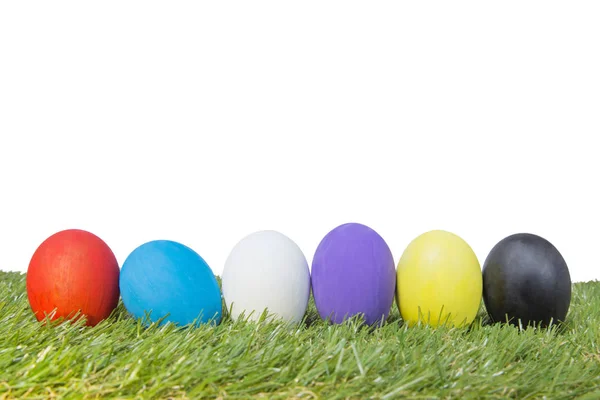 Coloridos huevos de Pascua hechos a mano sobre hierba verde aislados sobre un fondo blanco — Foto de Stock