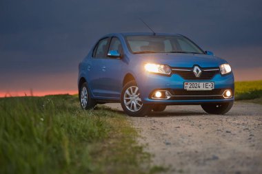 Gomel, Belarus - 15 Mayıs 2018: fırtınalı gökyüzü karşı alanındaki Park Reno Logan mavi araba