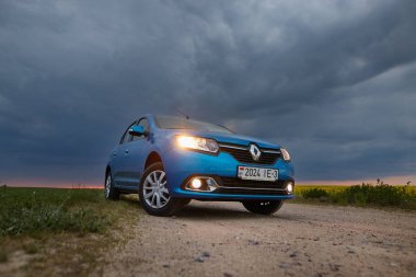 Gomel, Belarus - 15 Mayıs 2018: fırtınalı gökyüzü karşı alanındaki Park Reno Logan mavi araba