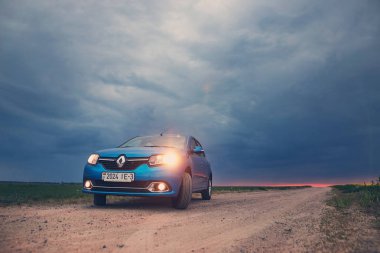 Gomel, Belarus - 15 Mayıs 2018: fırtınalı gökyüzü karşı alanındaki Park Reno Logan mavi araba