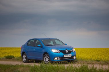 Gomel, Belarus - 15 Mayıs 2018: fırtınalı gökyüzü karşı alanındaki Park Reno Logan mavi araba
