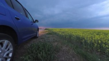 Gomel, Belarus - 15 Mayıs 2018: fırtınalı gökyüzü karşı alanındaki Park Reno Logan mavi araba.