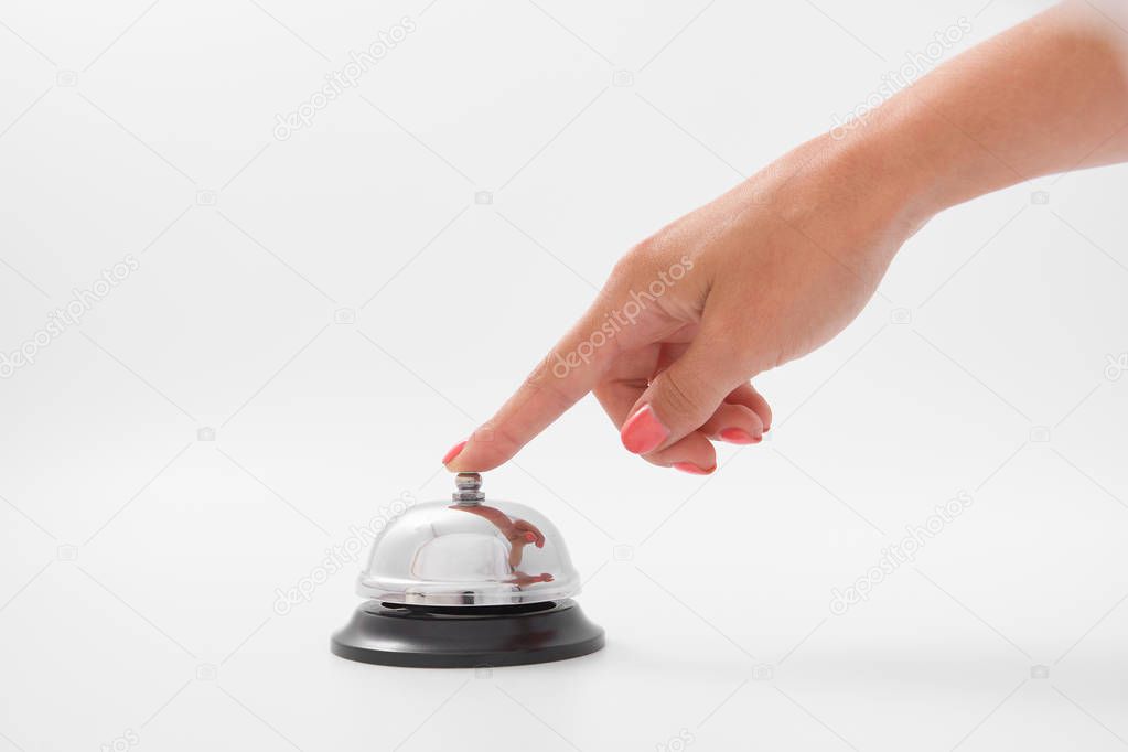 Hand of a woman using a hotel bell isolated