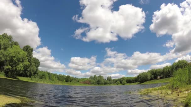 Lesní jezero pod modrou oblohu s mraky. — Stock video