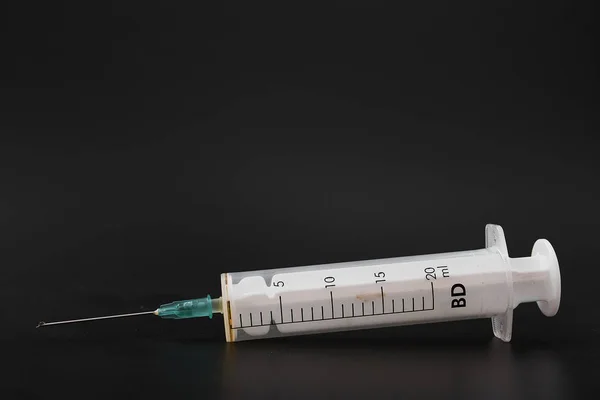 medical syringe with needle on black background