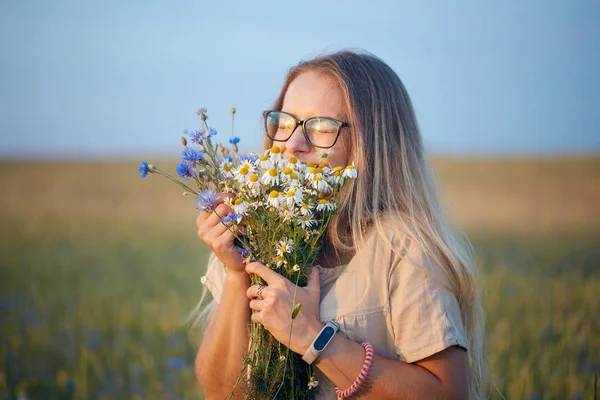 ヒナギクとフィールドのヤグルマギクの花束を持つ少女 — ストック写真