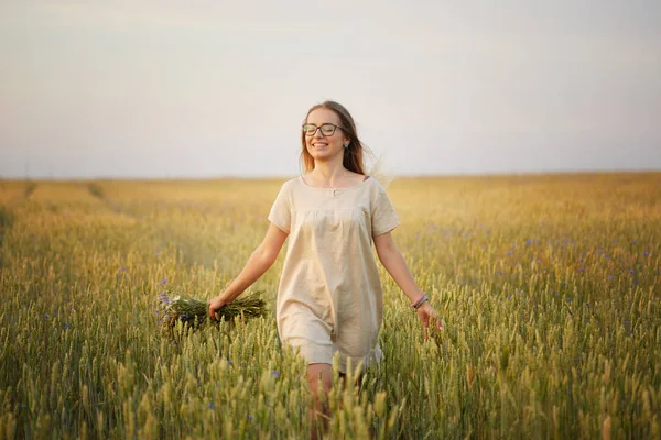 Çiçekli kız tahıl tarlasında yürüyor