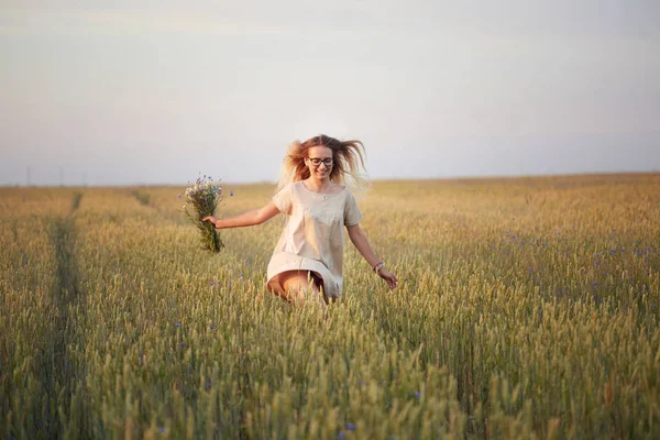 Çiçekli kız tahıl tarlasında yürüyor