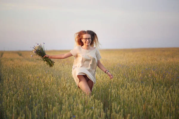 Çiçekli kız tahıl tarlasında yürüyor